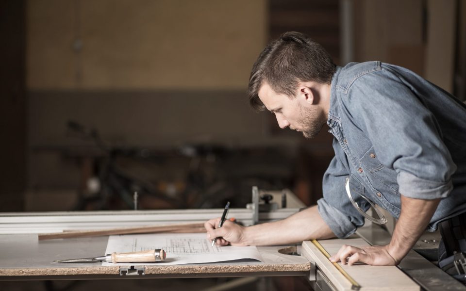 Carpenter looking at the plans Carpenter at work carefully looking at the plans